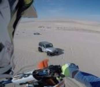 Un motard atterrit sur une Jeep en sautant depuis une dune dans le désert (Qatar)