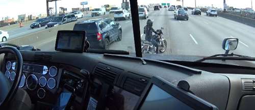 Un camion protège une motarde sur une autoroute