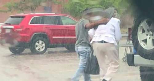 Une femme se démène sous la pluie, un adolescent lui donne la chemise qu’il porte