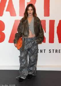 Elle, la sœur rarement vue d’Abbey Clancy, montre ses abdos dans un pantalon camouflage et un gilet alors qu’elle fait une apparition en solo à l’événement Banksy