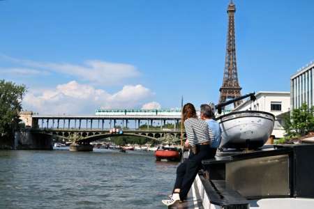 Reportage					Sur le pont d'une péniche, au pied de la tour Eiffel, avec vue sur les Jeux olympiques : de la carte postale à la réalité