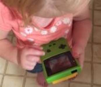 Une petite fille essaie de jouer sur une Game Boy