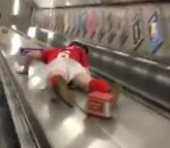 Un supporter de Chelsea FC descend un escalator en glissant