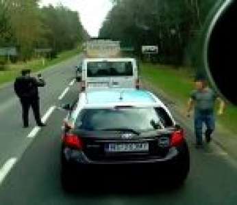 Un chauffeur de poids lourds dit quelques mots à un automobiliste qui jette ses détritus par la fenêtre