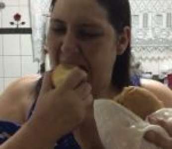 Une femme mange une pomme en reniflant un sandwich pendant un régime