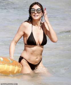 Heidi Klum, 50 ans, grésille dans un petit bikini noir sur une plage de Saint-Barthélemy alors qu’elle fait ses bagages sur son PDA avec son mari rockeur Tom Kaulitz, 34 ans.