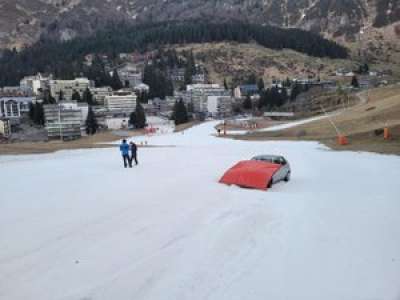 Un homme remonte une piste de ski avec sa voiture
