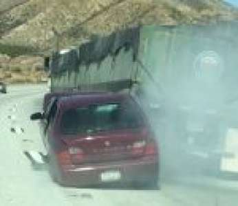 Un camion roule sur une autoroute avec une voiture accrochée à sa remorque (États-Unis)