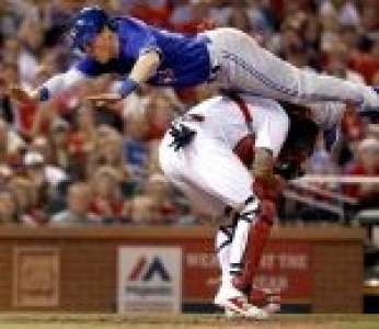 Le joueur de baseball Chris Coghlan réalise un saut acrobatique pour éviter le catcher