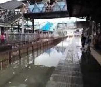 Un train passe dans une gare après de fortes pluies (Inde)