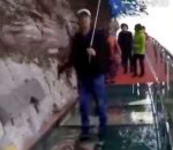 Un guide fait une blague à des touristes sur un pont en verre à 1 180 mètres d'altitude (Chine)