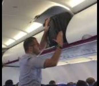 Un passager manque de logique pour ranger sa valise dans un avion