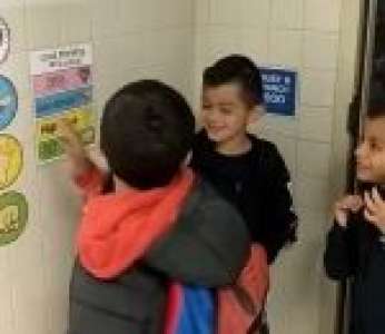 Des élèves font un câlin à un camarade de classe avant rentrer chez eux
