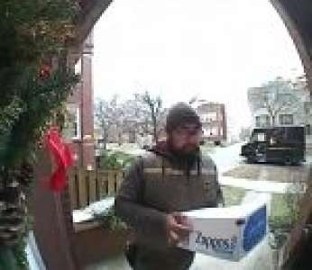 Un livreur UPS reçoit une visite surprise devant une porte d'entrée (États-Unis)