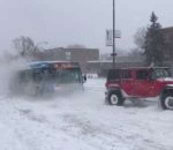 Trois SUV remorquent un bus coincé dans la neige (Canada)