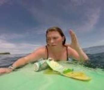 Une surfeuse n'a qu'à tendre les bras pour ramasser des déchets en plastique