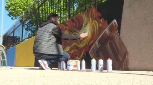 Un street-artiste peint une fresque aux couleurs de la flamme olympique pour son passage dans le Var
